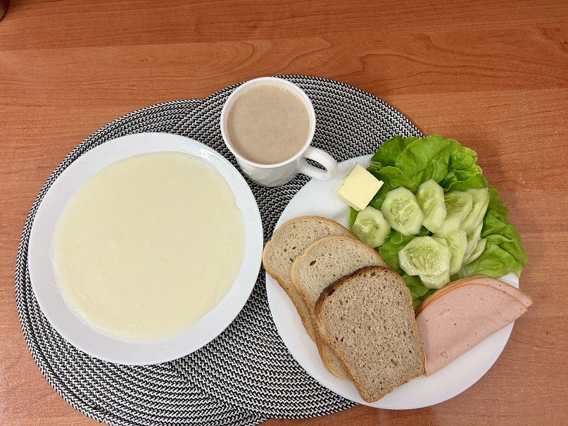 Na zdjęciu: Kasza manna na mleku, Kawa zbożowa z mlekiem, Chleb mieszany pszenno-żytni, Chleb Graham, Masło extra 82%, Filet zapiekany drobiowy, Ogórek świeży, Sałata zielona